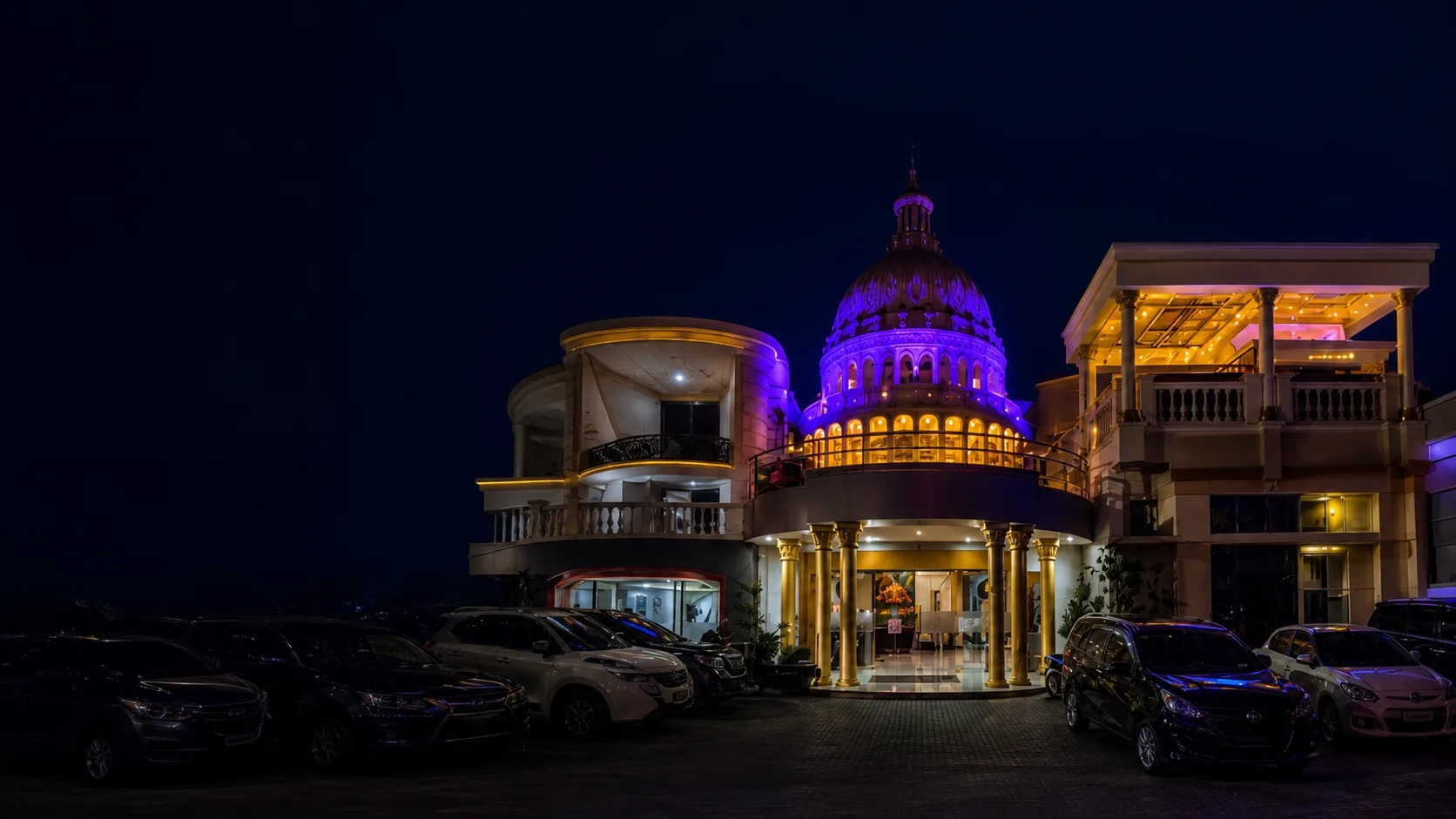Palais Dago Hotel illuminated at night